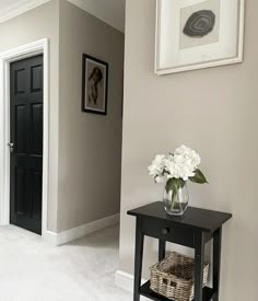 a vase with white flowers sitting on top of a table in front of a door