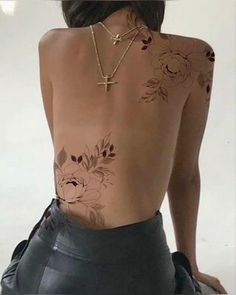 the back of a woman's body with flowers on her upper and lower back