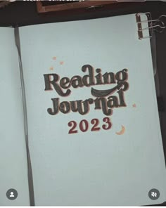 a notebook with the words reading journal written in brown and black on top of it