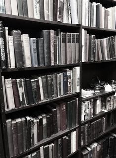 a bookshelf filled with lots of books in black and white