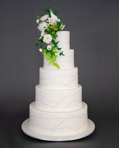 a white wedding cake with flowers on top