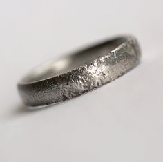 a close up of a silver ring on a white surface with no one around it