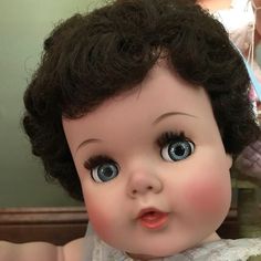 an old doll with black hair and blue eyes