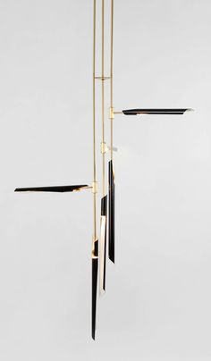 an abstract chandelier with black and gold fixtures hanging from it's sides