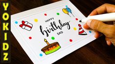 a hand holding a pen over a birthday card