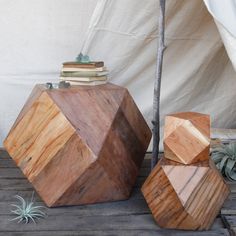 two wooden blocks sitting next to each other on top of a wooden floor near a tent