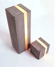 two concrete cubes sitting next to each other on a white surface with light coming from them