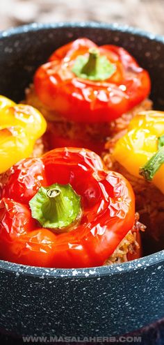 some red and yellow peppers in a black bowl