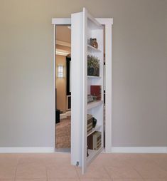 an open door in the middle of a room with shelves on each side and bookshelves below