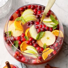 a bowl filled with fruit and garnish on top of a white marble counter