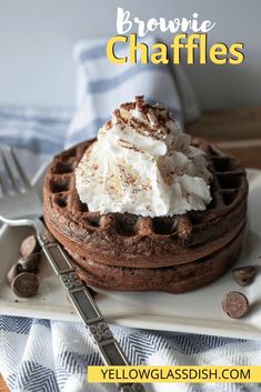 a waffle topped with whipped cream and chocolate chips on a plate next to a fork