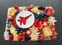 a platter filled with fruit and vegetables on top of a black tablecloth covered in red white and blue decorations