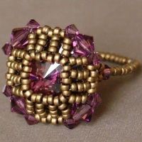 a ring made out of gold and pink beads