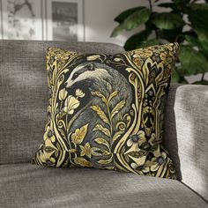 a black and gold pillow on a gray couch