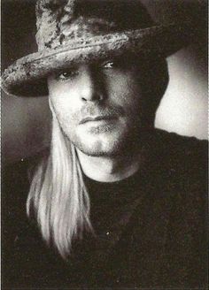 a man with long hair wearing a hat