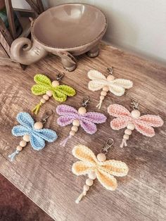 small crocheted dragonflys sitting on a table next to a teapot