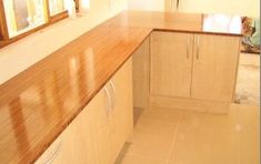 an empty kitchen with wooden counter tops and tile flooring