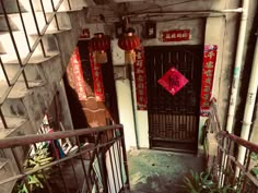 an entrance to a building with red lanterns hanging from it's ceiling and stairs