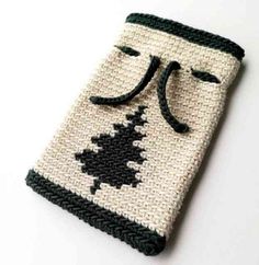 a crocheted bag with a black and white design on the front, sitting on a table