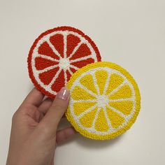 two pieces of fruit are being held by a person's hand on a white surface