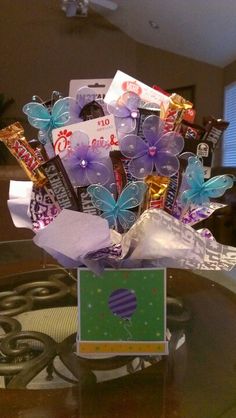 a vase filled with candy and butterflies on top of a table