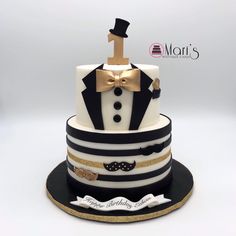 a black and white striped cake with a gold top hat, bow tie and mustache