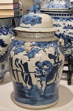 several blue and white vases sitting on top of a table next to each other