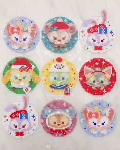 six cross stitch coasters in different designs on a marble surface with the words hello kitty written across them