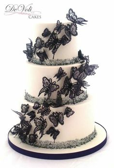 a three tiered cake with butterflies on it