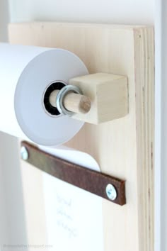 a roll of toilet paper is hanging on the wall next to a wooden door handle