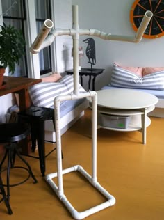 a living room with a couch, coffee table and white pipes on the floor in front of it