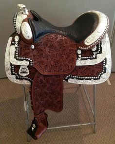 a brown and white saddle sitting on top of a metal stand