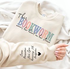 Bookworm Shirt, Bookish Shirt, Book Shirt, Book Sweatshirt, Librarian Gift, Book Lover Shirt, Gift for Reader, Reading Shirt, Banned Books Shirt, This Bookworm Wears her Heart on her Sleeve, Reading Shirt, Reading Sweatshirt, Bookish Tee, Book Nerd Shirt, Bookish Sweater, One More Chapter. Our sweatshirts and hoodies are available in various colors.  The actual color may slightly vary due to different lightings.  For Sweatshirt, we use Gildan Heavy Blend Crewneck Sweatshirt. Material is 60% Polyester and 40% Cotton. For Hooded Sweatshirt, we use Heavy Blend Adult Hooded Sweatshirt. Material is 50% Cotton and 50% Polyester. Please select the size and color before adding it to the cart. Please check the Size Chart in the pictures to choose the correct size. Return Policy No Return Accepted. Book Lover Shirt, Book Shirt Ideas, Bookish Tees, Random Trinkets, Reading Sweatshirt, Banned Books Shirt, Book Nerd Shirts, Nerd Shirt, Books Shirt