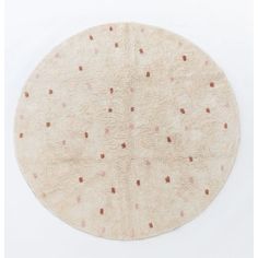 a round rug with pink and brown dots on white background, in the shape of a circle