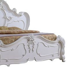 a white bed with ornate carvings on the headboard and foot board is shown in this image