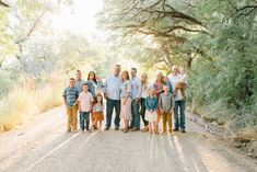 a group of people standing in the middle of a dirt road with trees behind them