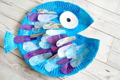 a paper plate fish made to look like it is painted with blue and purple colors