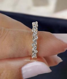 a woman's hand holding a diamond ring