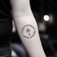 a woman's arm with a tree tattoo on the left side of her arm