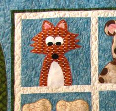 a close up of a quilted wall hanging with pictures of cats and dogs on it