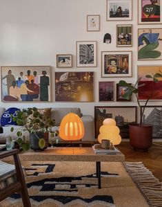 a living room filled with furniture and lots of pictures on the wall above it's coffee table