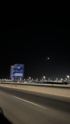 an airplane is flying in the night sky over a highway with buildings and traffic lights