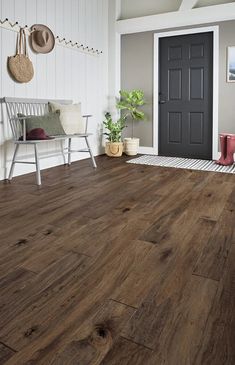 a living room with wood floors and white walls, including a black door in the center