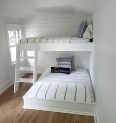 a bunk bed in a room with white walls and wood flooring on the bottom level