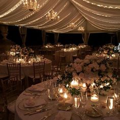 the tables are set with candles and flower centerpieces for an elegant wedding reception