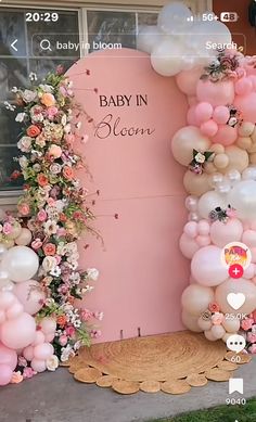 the baby in bloom balloon arch is decorated with pink and white balloons, flowers, and greenery