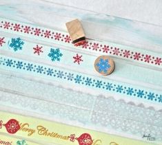 a wooden stamper sitting on top of some decorative paper tape with snowflakes