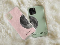 two phone cases sitting on top of a white fur covered floor next to each other