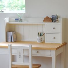 a white desk with two drawers and a wooden shelf