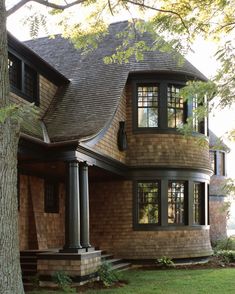 a large brown brick house sitting next to a tree